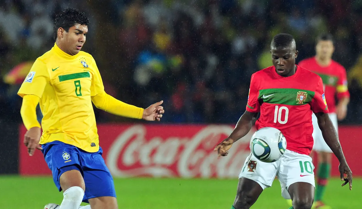 Pemain Timnas Brasil U-20, Casemiro (kiri) berusaha merebut bola dari pemain Portugal U-20, Sana pada pertandingan final Piala Dunia U-20 2011 yang berlangsung di El Campin, Bogota, Kolombia, Sabtu (20/8/2011). (AFP/Luis Acosta)