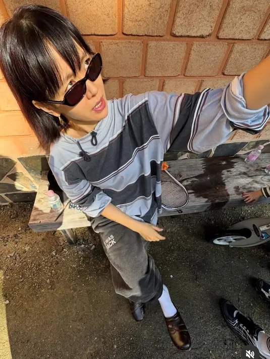 <p>Saat itu, ia tampil santai mengenakan atasan lengan panjang oversize dengan motif bergaris warna hitam dan baby blue dengan model tali hitam di kerah. [@yejinhand]</p>