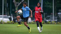 Pemain Timnas Indonesia U-20 berebut bola dengan pemain Tim Putri PW Saputra, Subang pada laga uji coba untuk persiapan Kalifikasi Piala Asia Wanita U-20 2023 yang berlangsung di Lapangan A, Kompleks Stadion Utama Gelora Bung Karno (SUGBK), Senayan, Jakarta, Kamis (02/03/2023). (Bola.com/Bagaskara Lazuardi)