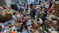 Para relawan mengatur bermacam barang hasil penggalangan dana untuk korban Harvey di Dallas Utara, Selasa (29/8). Para donatur bisa memberikan bantuan berupa barang atau uang melalui situs milik Charity Navigator. (Tony Gutierrez/AP)