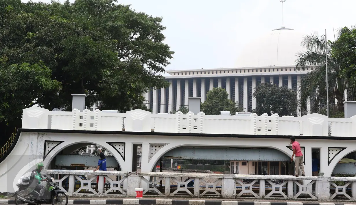 Dua pekerja sedang melakukan pengecatan pintu air Istiqlal, Jakarta Pusat, Senin (14/11). Pengecatan dilakukan untuk menjaga pintu air yang merupakan salah satu cagar budaya tersebut agar tetap bersih dan terawat. (Liputan6.com/Immanuel Antonius)