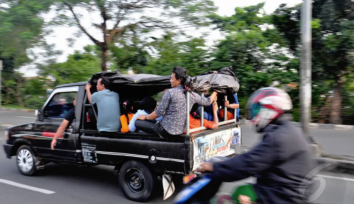 Meski hal itu disadari mengundang maut serta melanggar aturan lalu lintas, mereka tetap nekat berpergian menggunakan mobil bak terbuka, Jakarta, Kamis (31/7/14). (Liputan6.com/Faizal Fanani)