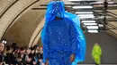 Seorang model memperagakan busana kreasi dari perancang Inggris, Craig Green selama gelaran London Fashion Week Men's di London pada 7 Januari 2019. Craig Green memamerkan pakaian untuk Musim Gugur/Musim Dingin 2019. (NIKLAS HALLE'N/AFP)