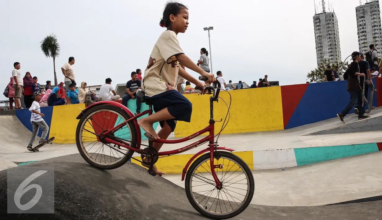 Seorang anak perempuan  bersepeda di Taman Kalijodo, Jakarta, Minggu (15/01). Sejak skate park dan lintasan sepeda BMX dibuka untuk umum, taman tersebut tidak pernah sepi pengunjung. (Liputan6.com/Fery Pradolo)