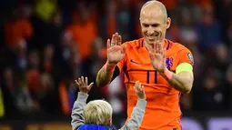 Gelandang Munchen, Arjen Robben bersama anaknya usai pertandingan melawan Swedia pada kualifikasi Piala Dunia 2018 di stadion Arena, Amsterdam (10/10). Dua gol yang dicetak Robben gagal mengantar Der Oranje lolos. (AFP Photo/Emmanuel Dunand)