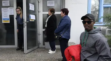 TKA menunggu di depan kantor yang terbuka untuk orang asing yang mengajukan visa, izin kerja, dan izin tinggal di Kroasia, di Zagreb pada 11 April 2023. (AFP/DENIS LOVROVIC)