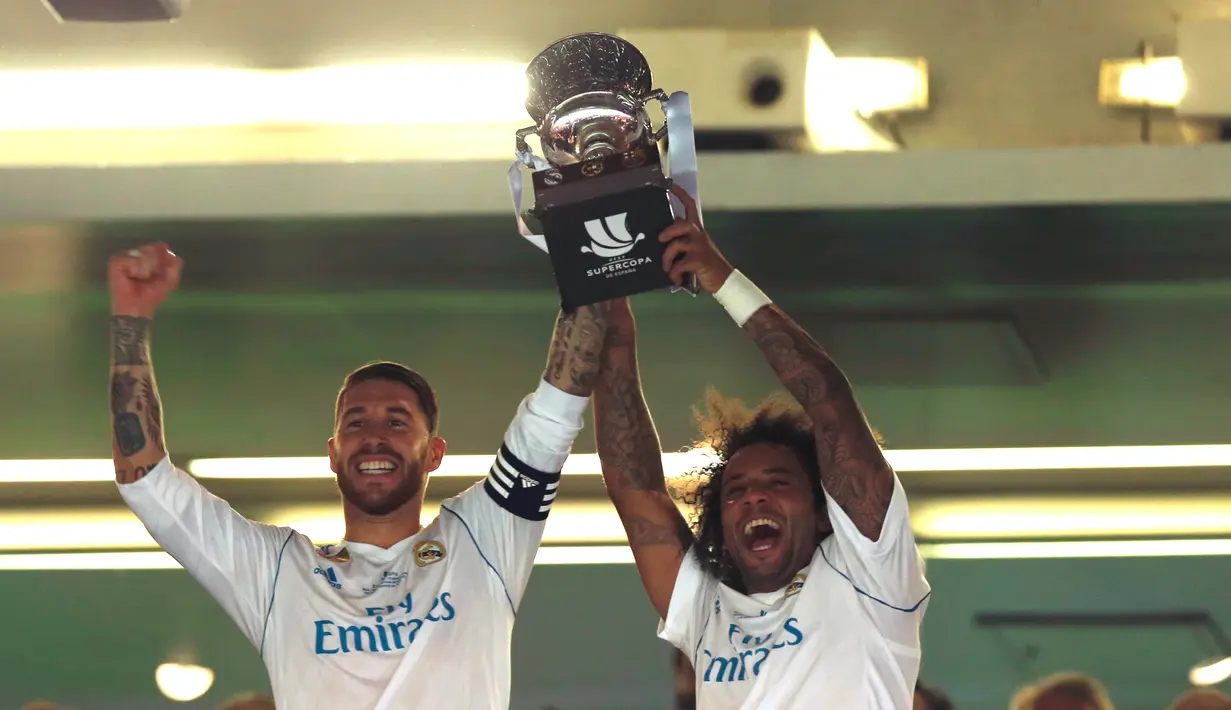 Bek Real Madrid, Sergio Ramos dan Marcelo mengangkat trofi Piala Super Spanyol 2017 usai pertandingan melawan Barcelona di stadion Santiago Bernabeu, Spanyol (16/8). Real Madrid menang 2-0 atas Barcelona dengan skor agregat 5-1. (AP Photo/Francisco Seco)