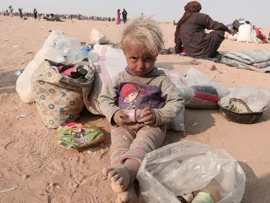 Seorang anak pengungsi Irak beristirahat usai melarikan diri dari kekerasan di Mosul yang dikuasai oleh ISIS di perbatasan Irak, Hasaka Governorate (23/10). Selain Irak pengungsi dari Suriah juga berkumpul dari dekat perbatasan Irak. (REUTERS/Rodi Said)