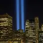 Sorotan cahaya kembar berwarna biru untuk peringati peristiwa serangan 9/11 di Kota New York, Minggu (10/9). Dua cahaya biru tegak lurus itu melambangkan menara kembar WTC yang menjadi sasaran serangan bunuh diri tersebut. (AP Photo/Mark Lennihan)