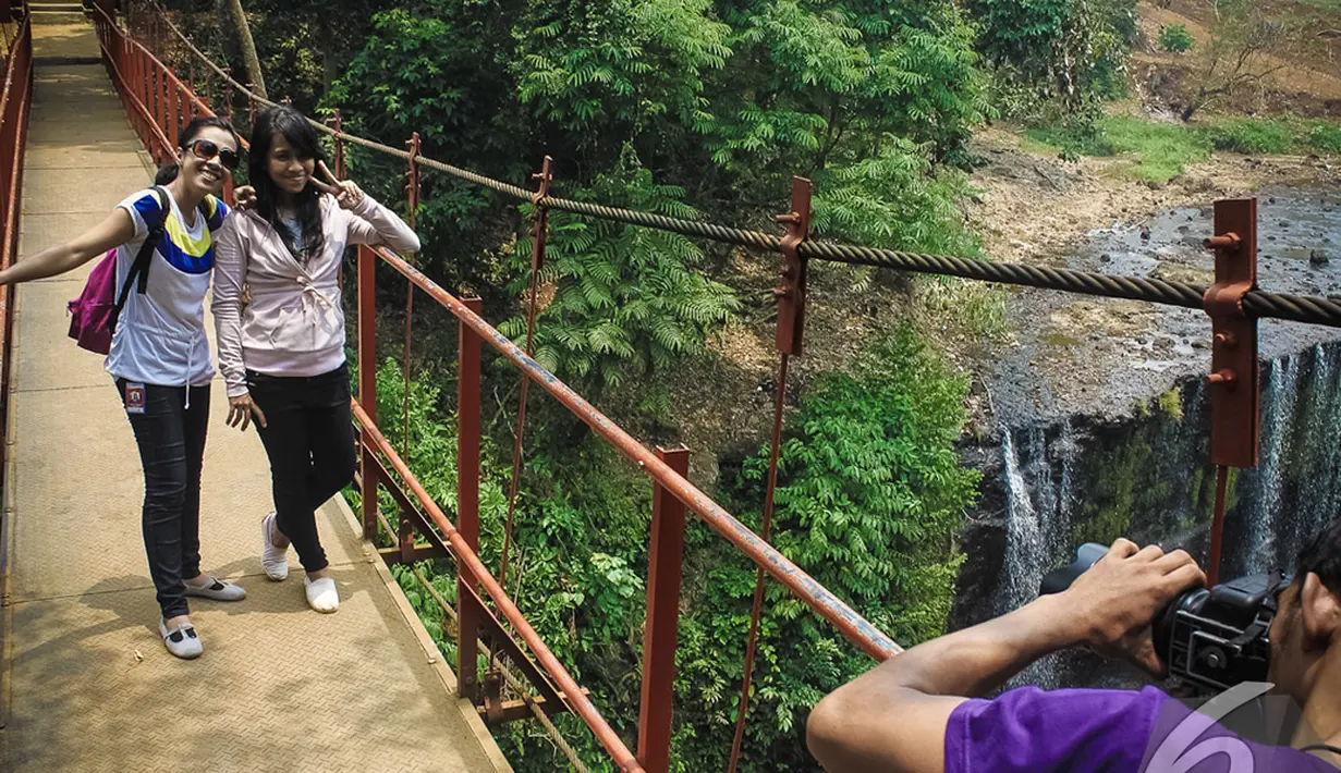 Wisatawan mengabadikan gambarnya di jembatan Air Terjun Temam, Sumatera Selatan, Jumat (10/10/2014) (Liputan6.com/Faizal Fanani)