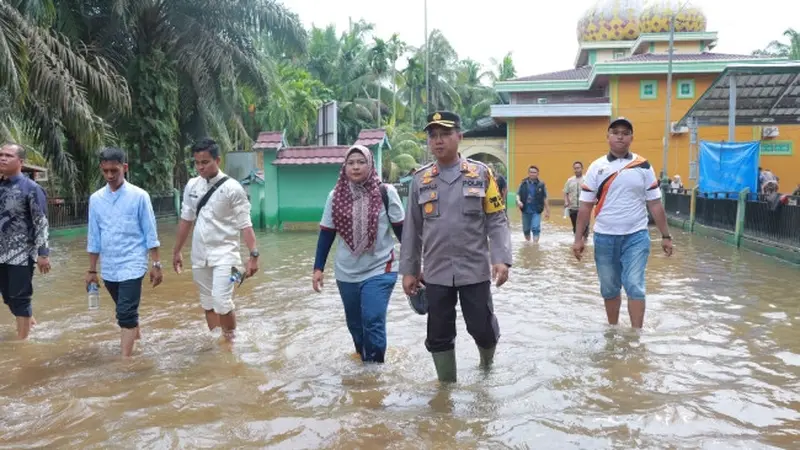 Kapolres Kampar AKBP Ronald Sumaja meninjau lokasi tempat pemungutan suara yang terendam banjir.