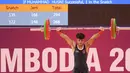 Atlet angkat besi Indonesia, Muhammad Husni berkompetisi pada nomor angkat besi putra 55 kg SEA Games 2023 di Taekwondo Hall Olympic Complex, Phnom Penh, Kamboja, Sabtu (13/05/2023). Husni berhasil meraih medali perunggu setelah melakukan total angkatan 233 kg, dengan rincian 133 kg snatch dan 120 clean & jerk. (Bola.com/Abdul Aziz)