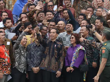 Presiden Joko Widodo atau Jokowi foto bersama perwakilan nelayan seluruh Indonesia di Istana Negara, Jakarta, Selasa (22/1). Jokowi mengingatkan para nelayan serta pengusaha perikanan untuk menggunakan Bank Mikro Nelayan. (Liputan6.com/Angga Yuniar)