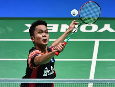 Tunggal putra Indonesia, Anthony Sinisuka Ginting melakukan servis ke arah lawannya tunggal putra Jepang, Kento Momota pada babak perempat final Jepang Terbuka 2019 di Tokyo, Jumat (26/7/2019). Anthony Ginting, tersingkir setelah kalah dengan skor 13-21, 22-20 dan 15-21. (TOSHIFUMI KITAMURA/AFP)