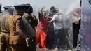 Sejumlah biksu dan aktivis bentrok dengan polisi saat aksi protes di kota pelabuhan selatan Hambantota, Sri Lanka (7/1). Meski warga lokal akan di berikan lahan baru mereka tetap menolak pembangunan zona industri tersebut. (AFP/Ishara S. Kodikara)