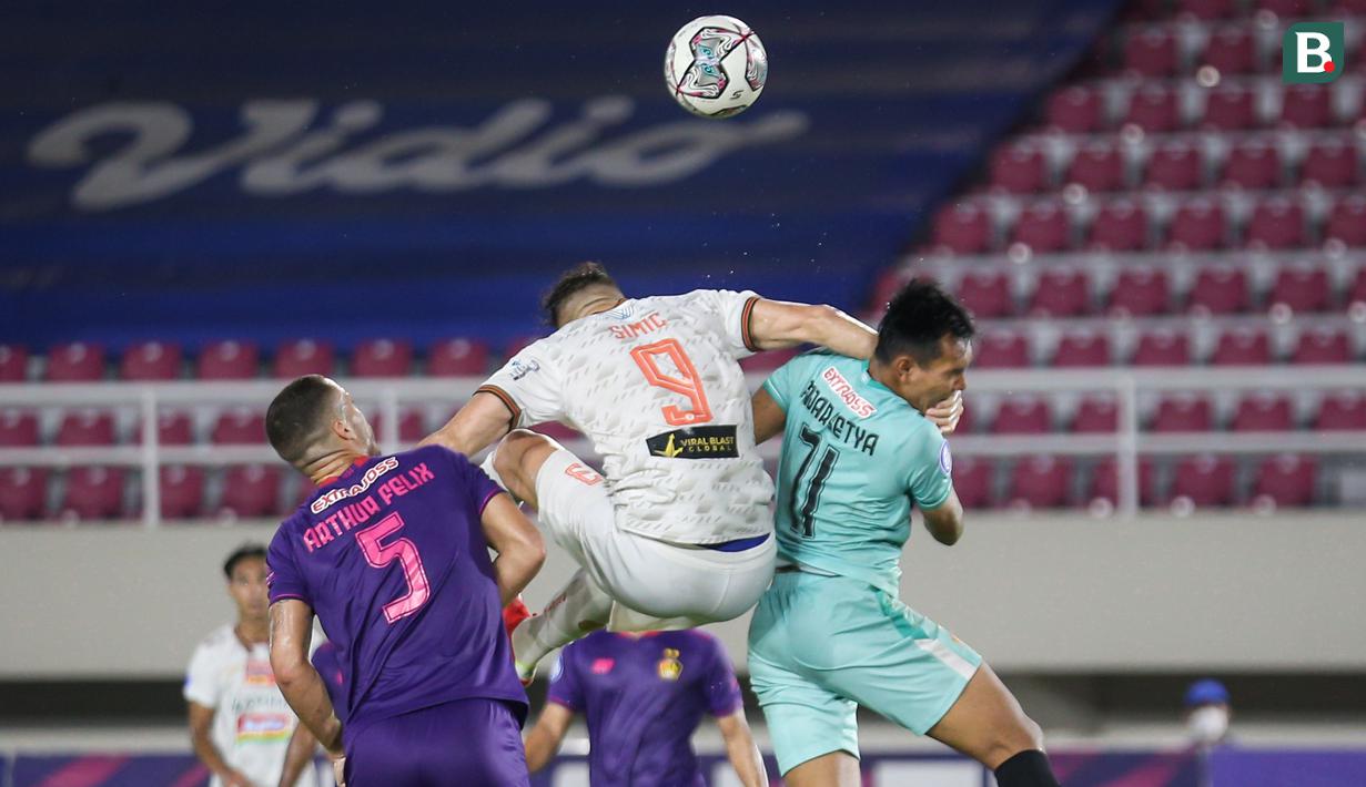 Pemain Persija Jakarta, Marko Simic (tengah) berduel udara dengan kiper Persik Kediri, Fajar Setya Jaya (kanan) dalam laga pekan ke-10 BRI Liga 1 2021/2022 di Stadion Manahan, Solo, Sabtu (30/10/2021). (Bola.com/Bagaskara Lazuardi)