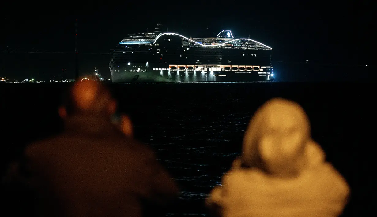 Warga menyaksikan kapal pesiar MSC World Europa meninggalkan pelabuhan Saint-Nazaire, Prancis barat pada 26 Oktober 2022.  Kapal raksasa ini memiliki kapasitas 6.762 penumpang. (AFP/Sebastien Salom Gomis)