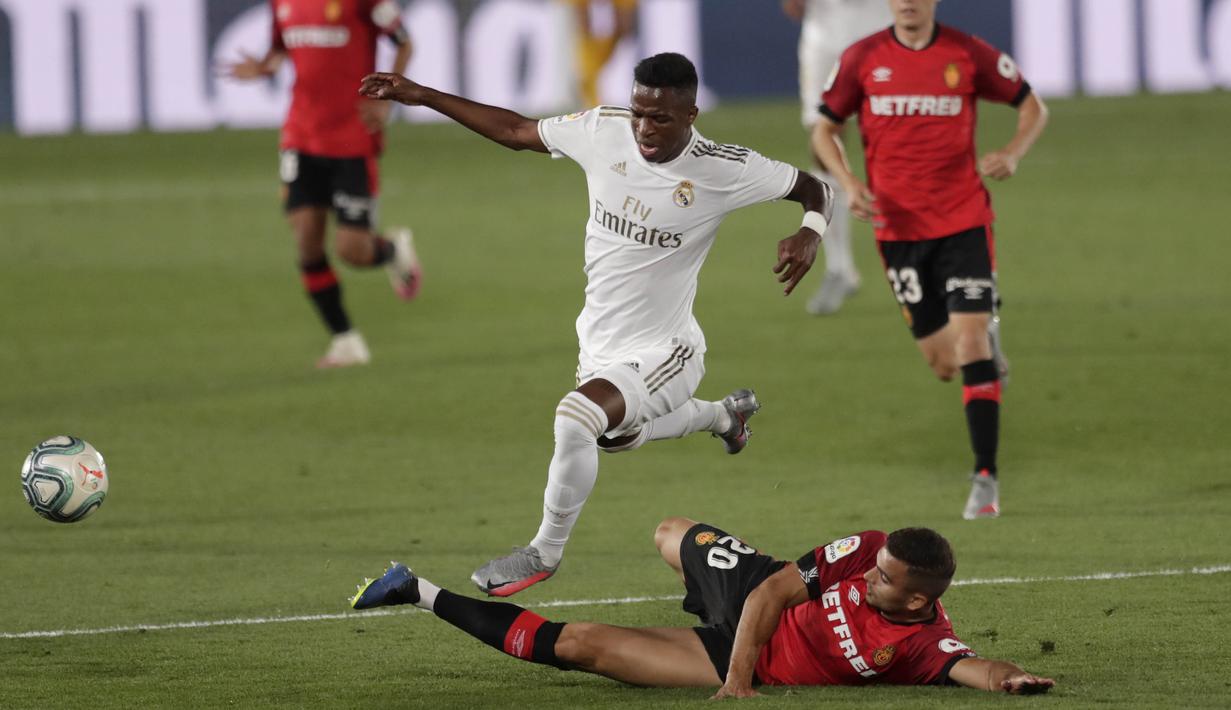 Pemain Real Madrid, Vinicius Junior, berusaha melewati pemain Real Mallorca pada laga La Liga di Stadion Alfredo Di Stefano, Kamis (25/6/2020). Real Madrid menang 2-0 atas Real Mallorca. (AP/Bernat Armangue)
