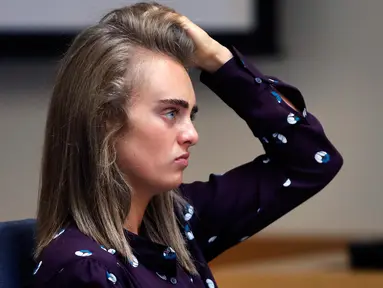 Terdakwa Michelle Carter merapihkan rambutnya saat menghadiri sidang di Pengadilan Negeri Taunton di Taunton, Mass, (8/6). Wanita berusia 20 tahun ini dituduh melakukan pembunuhan pada bulan Juli 2014. (AP Photo/Charles Krupa, Pool)