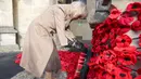 Ratu Inggris, Camilla, meletakkan karangan bunga poppy di tugu peringatan Perang Dunia I di Gereja St. Bartholomew di Corsham, Inggris pada Selasa 28 Oktober 2025. Ratu Camilla mengunjungi The Poppy Project di Coresham, sebuah pameran bunga poppy rajutan dan kaitan yang dibuat untuk memperingati 80 tahun berakhirnya Perang Dunia II. (Chris Jackson/POOL/AFP)
