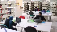 Pengunjung membaca buku di Perpustakaan Nasional (Perpusnas), Jakarta, Kamis (10/6/2020). Perpusnas membuka kembali membuka pelayanan mulai Kamis ini, 11 Juni 2020, dengan menyiapkan protokol kesehatan setelah beberapa bulan tutup akibat COVID-19. (Liputan6.com/Angga Yuniar)