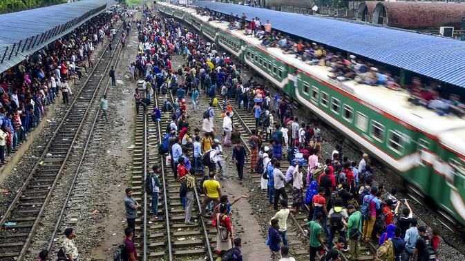 Ratusan pemudik bersiap menaiki sebuah kereta yang atapnya telah penuh sesak oleh penumpang untuk menuju kampung halaman di Dhaka, Bangladesh pada 4 Juni 2019. Sebagaimana terjadi di Indonesia, masyarakat Bangladesh pun memiliki tradisi mudik saat Idul Fitri. (MUNIR UZ ZAMAN/AFP)