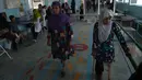 Wanita Afgan berlatih menggunakan kaki palsu, dibantu menggunakan tongkat, di pusat ortopedik Komite Internasional Palang Merah (ICRC), rumah sakit bagi korban perang dan yang diamputasi, di Kabul, Minggu (3/4).  (SHAH Marai/AFP)