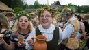 Keceriaan warga saat mengikuti Festival Rasos di Rumsiskes, Lithuania, Selasa (23/6/2020). Festival Rasos merupakan perayaan yang diadakan pada pertengahan musim panas di Lithuania. (Xinhua/Alfredas Pliadis)