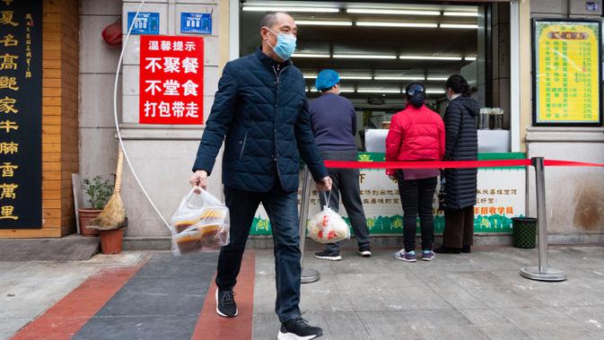 Seorang pelanggan meninggalkan restoran mi sapi dengan membawa makanan untuk dibawa pulang di Xiangyang, Provinsi Hubei, China tengah, pada 16 Maret 2020. Beberapa restoran mi sapi di Xiangyang kembali melanjutkan bisnis dengan layanan take away pada Senin (16/3). (Xinhua/Xie Jianfei)
