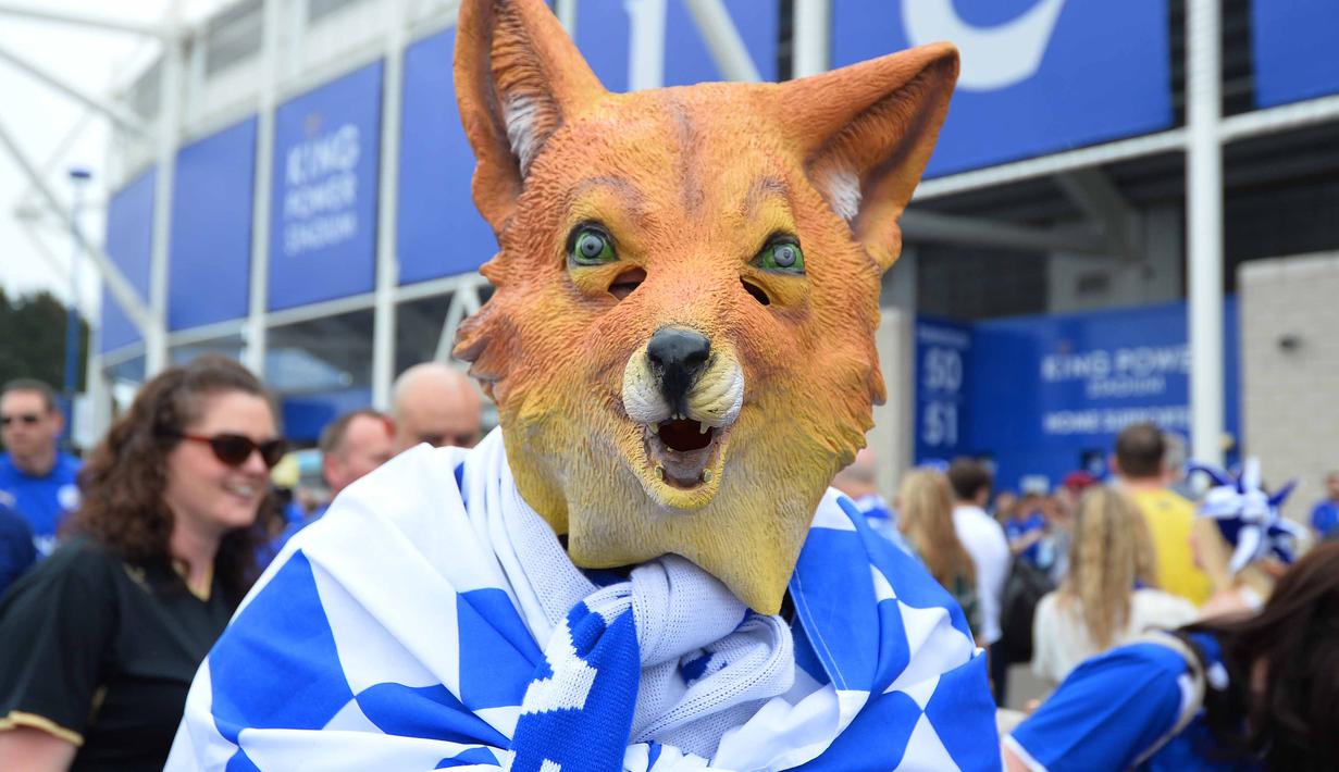 Seorang fans Leicester City mengenakan topeng maskot kebanggan Leicester City saat merayakan titel juara Liga Inggris 2015-2016 di Areal Stadion King Power (7/5/2016). (AFP/Glyn Kirk)