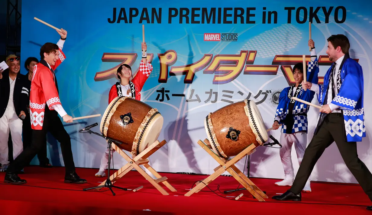 Sutradara Jon Watts (kanan) dan Tom Holland (kiri) menabuh gendang saat pemutaran perdana filmnya di Tokyo, Senin (7/8). Tabuhan gendang turut meramaikan pemutaran perdana film produksi Marve Studio ini. (Shizuo Kambayashi /AP)