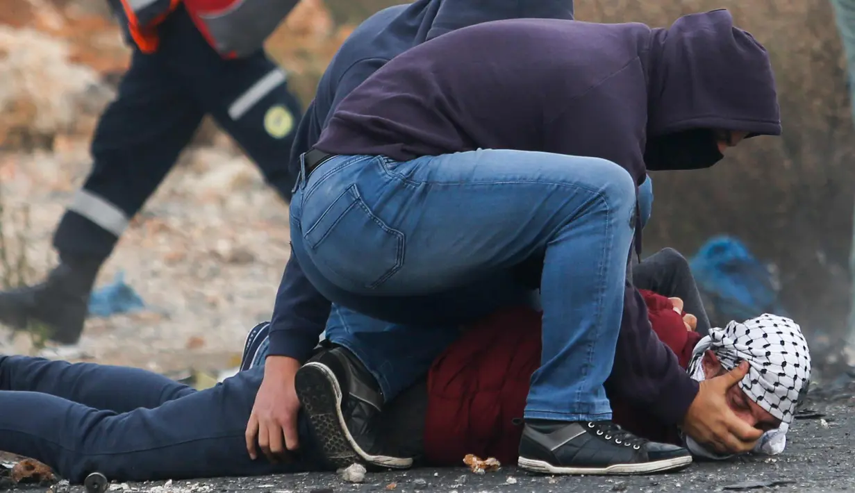 Polisi Israel menangkap seorang demonstran Palestina di kota Ramallah, Tepi Barat, (13/12). Lebih dari 100 warga Palestina saat demonstrasi selama tiga hari di wilayah pendudukan Palestina diciduk polisi Israel. (AP Photo / Nasser Shiyoukhi)