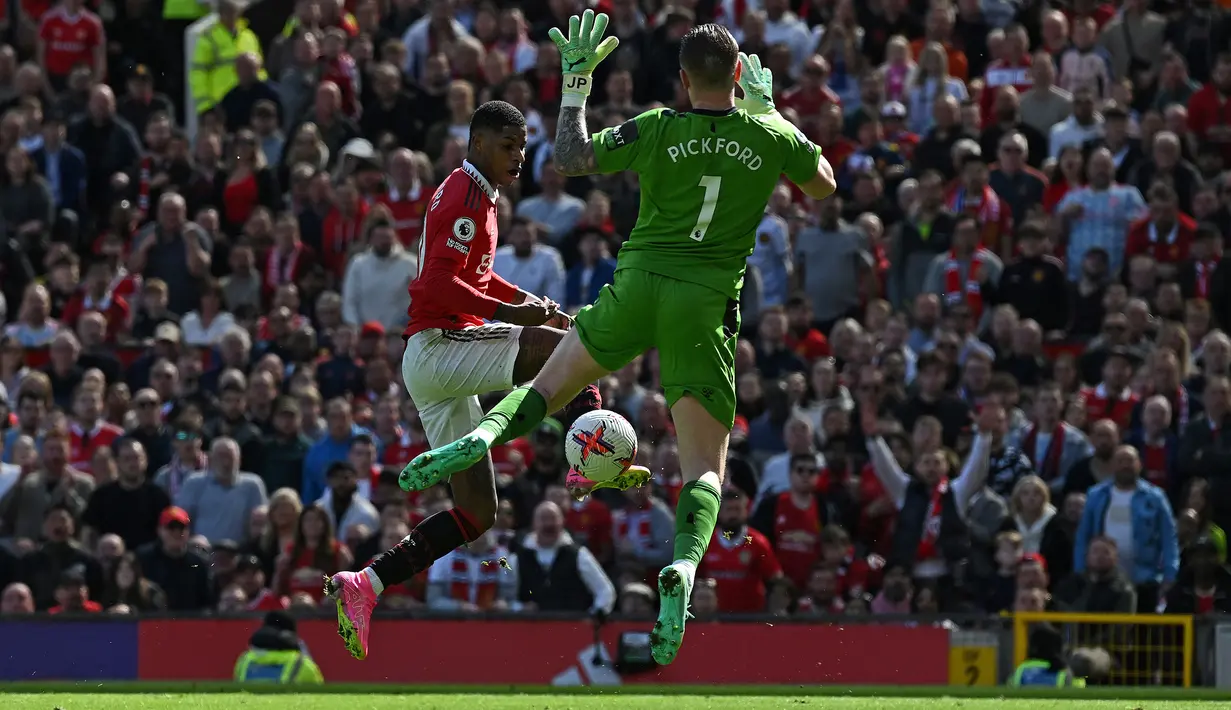 Kiper Everton, Jordan Pickford berusaha menutup ruang tembak striker Manchester United, Marcus Rashford pada laga lanjutan pekan ke-30 Liga Inggris 2022/2023, Sabtu (8/4/2023) di Old Trafford Stadium, Manchester. (AFP/Paul Ellis)