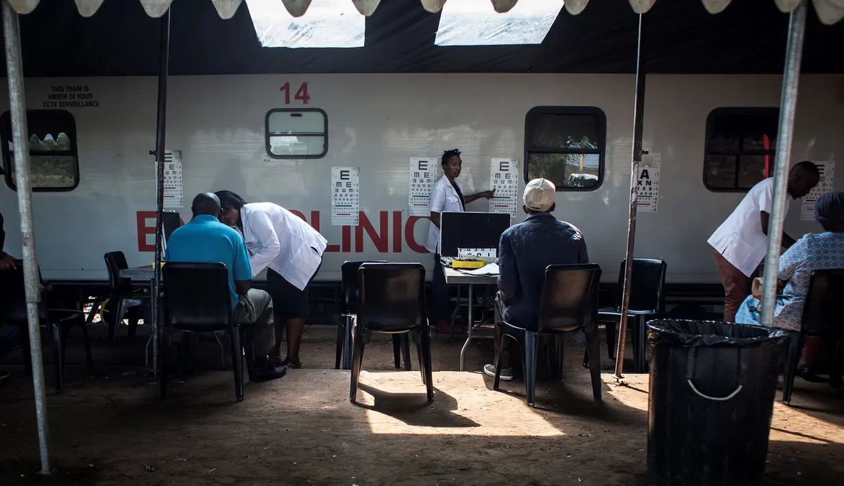 Sejumlah dokter melayani pasien saat Kereta Phelophepha singgah di Pienaarsrivier, Afrika Selatan, Senin (6/3). Phelophepha merupakan cara pemerintah Afsel memberikan layanan kesehatan bagi masyarakat di wilayah terpencil. (AFP Photo/ JOHN WESSELS)