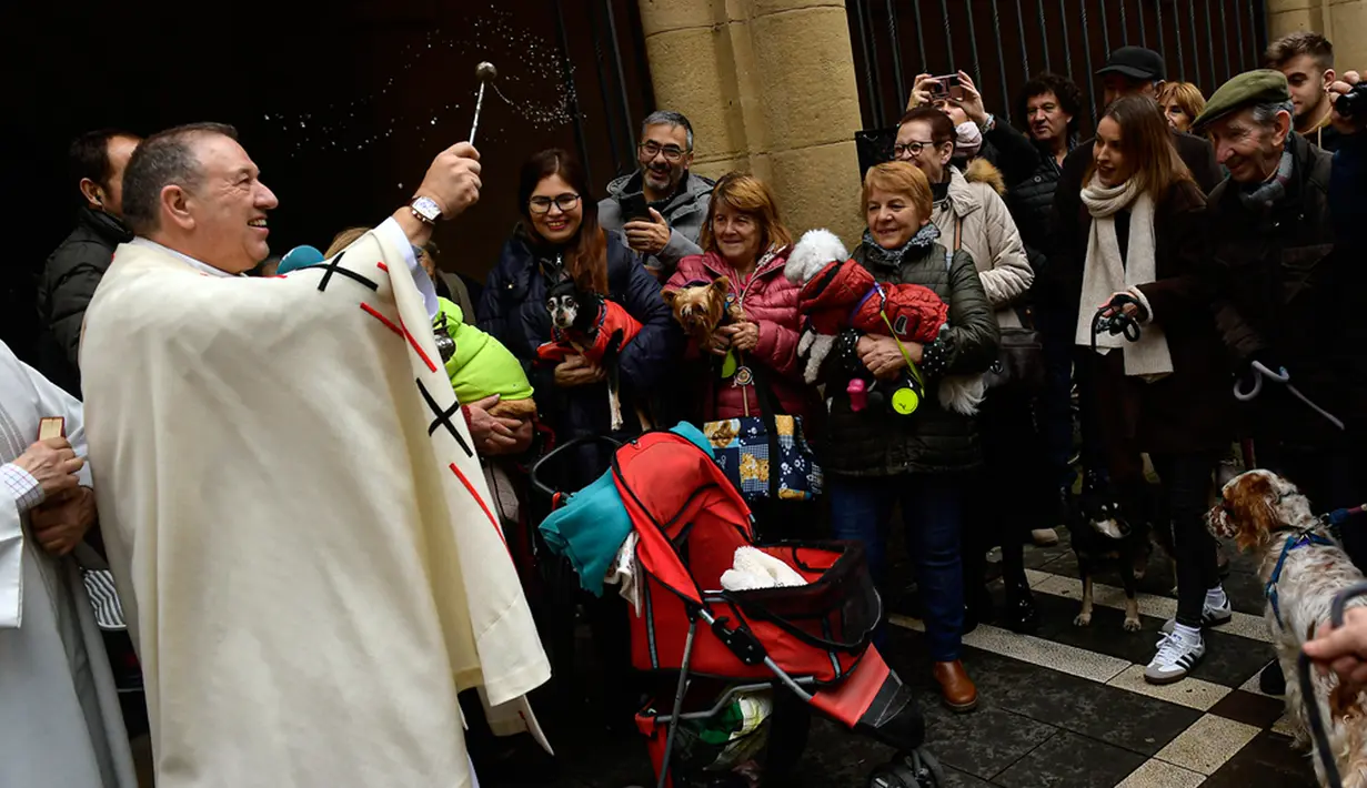 Pastor Cesar Magana (kiri) memberkati hewan peliharaan pada perayaan Santo Antonius di Pamplona, Spanyol, Rabu (17/1/2024). (AP Photo/Alvaro Barrientos)