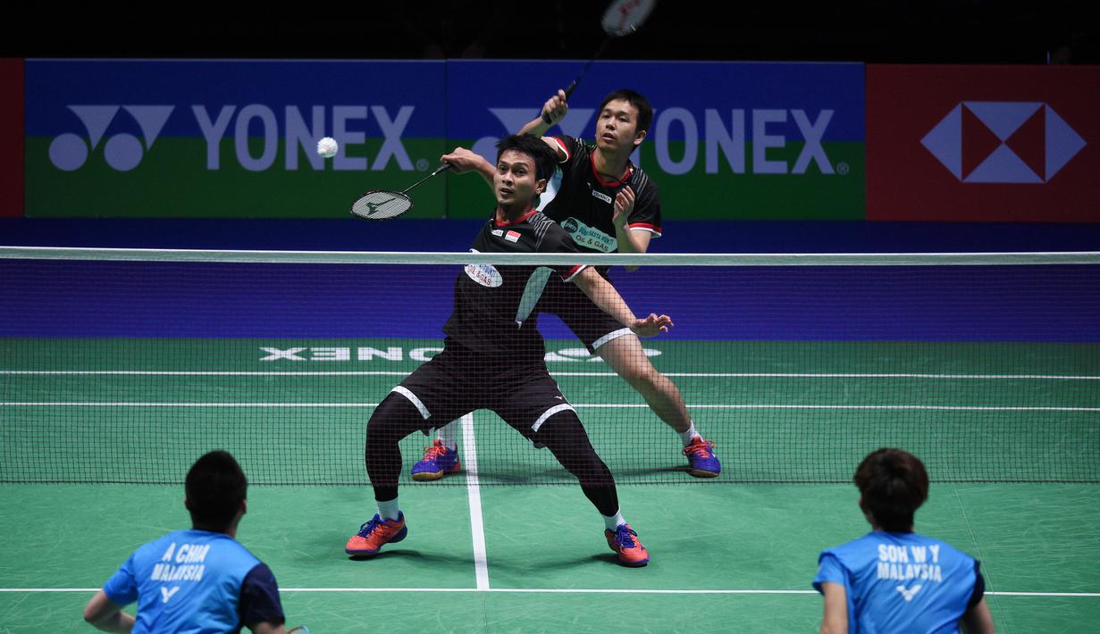 Mohammad Ahsan mencoba bermain bola pendek di laga final All England 2019 yang berlangsung di Arena Birmingham, Minggu (10/3). Di final Hendra/Ahsan menang 11-21, 21-14, 21-12 atas Aaron Chia/Soh Wooi Yik. (AFP/Oli Scarff)