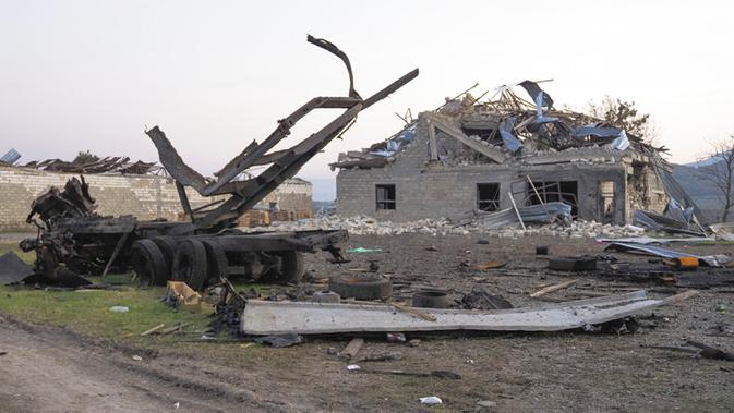 Sebuah bangunan dan kendaraan hancur setelah penembakan oleh artileri Azerbaijan selama konflik militer dengan Armenia di luar Stepanakert, wilayah separatis Nagorno-Karabakh, Senin (19/10/2020). Pertempuran di Nagorno-Karabakh berkecamuk selama lebih dari tiga minggu. (AP Photo)