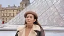 Lihat cantiknya inspirasi holiday look dari Enzy Storia. Dalam foto ini, ia berpose di depan bangunan ikonis di Paris, mengenakan turtleneck cokelat sebagai innerwear, yang ditumpuknya dengan jaket, dipadu dengan rok bernuansa senada dengan jaketnya, serta stoking hitam. Tak lupa ia menambahkan sentuhan aksesori berupa topi sebagai pemanis yang sempurna untuk keseluruhan tampilannya. Foto: Instagram.