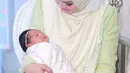 Penyanyi Siti Nurhaliza menggendong anak pertamanya Siti Aafiyah saat acara prosesi akikah. Anak tersebut merupakan anak pertama dari pernikahannya dengan Datuk Seri Khalid Mohamad. (instagram.com/ctdk)