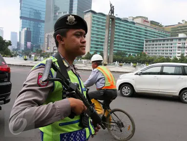Anggota kepolisian bersenjata laras panjang berjaga di kawasan Bundaran HI, Jakarta, Jumat (15/1).  Pasca-teror di kawasan Sarinah, Jalan MH Thamrin, Polri meningkatkan status keamanan Indonesia menjadi siaga satu. (Liputan6.com/Faizal Fanani)