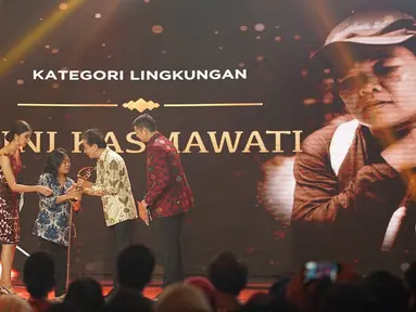 Penyandang tunanetra Tini Kasmawati menerima penghargaan kategori lingkungan dari Tokoh Filantropis, Irwan Hidayat dalam ajang Liputan6 Awards di Jakarta, Sabtu (25/5/2019). (Liputan6.com/Immanuel Antonius)