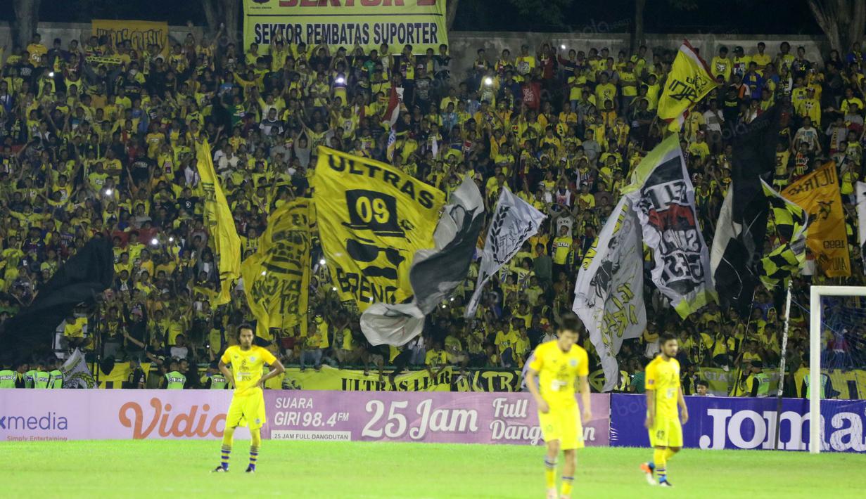 Suporter Gresik United memberikan dukungan kepada timnya sat melawan Sriwijaya FC pada laga Torabika SC2016 di Stadion Tridarma Gresik, Minggu (12/6/2016).  (Bola.com/Nicklas Hanoatubun)