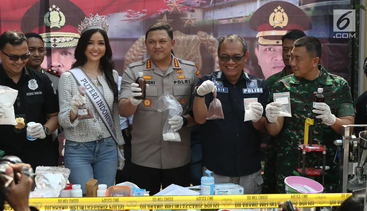 Kapolres Jakarta Barat Kombes Pol Hengki Haryadi (tengah) menunjukkan bahan pembuat narkoba saat rilis di sebuah perumahan di Pondok Rajeg, Cibinong, Senin (24/9). Polisi juga menyita 158 gram sabu, 3000 pil ekstasi. (Liputan6.com/Helmi Fithriansyah)