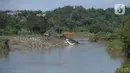 Pekerja menggunakan alat berat mengeruk sampah yang longsor di TPA Cipeucang, Serpong, Tangerang Selatan, Banten, Sebtu (23/5/2020). Turap penahan sampah TPA Cipeucang longsor pada 22 Mei 2020 dan hampir menutupi aliran Sungai Cisadane yang berada di sebelahnya. (merdeka.com/Dwi Narwoko