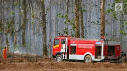 Mobil Pemadam Kebakaran berada di lokasi kebakaran yang melanda hutan jati Kawasan Mijen Semarang, Sabtu (21/9/2019). Musim kemarau yang panjang dan kondisi yang kering mempermudah api menyebar di kawasan tersebut. (Liputan6.com/Gholib)