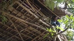 Seorang pria duduk di atas rumah pohon di desa Taik Kyi, Myanmar, 14 Januari 2016. Warga di desa ini terpaksa membuat rumah pohon untuk tempat berlindung dari kawanan gajah liar yang belakangan ini kerap menyerang desa Taik Kyi. (AFP PHOTO/Ye Aung THU)