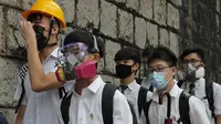 Para siswa sekolah mengenakan topeng dan helm berjalan di luar St. Paul's College selama protes di Hong Kong, Selasa (3/9/2019). Puluhan ribu siswa di Hong Kong memprotes terhadap gerakan anti-pemerintah. (AP Photo/Kin Cheung)