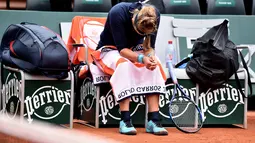 Victoria Azarenka tertunduk menahan sakit saat melawan Karin Knapp pada babak pertama Prancis Terbuka 2016 di Roland Garros, Paris, (24/5/2016). (EPA/Christophe Petit Tesson)