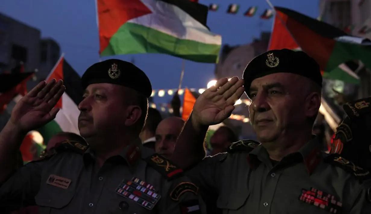 Petugas otoritas Palestina memberikan hormat saat menunggu live-screening pidato Presiden Mahmud Abbas sebelum pengibaran bendera Palestina di markas besar PPB di New York, Rabu (30/9/2015). (AFP PHOTO/ABBAS Momani)