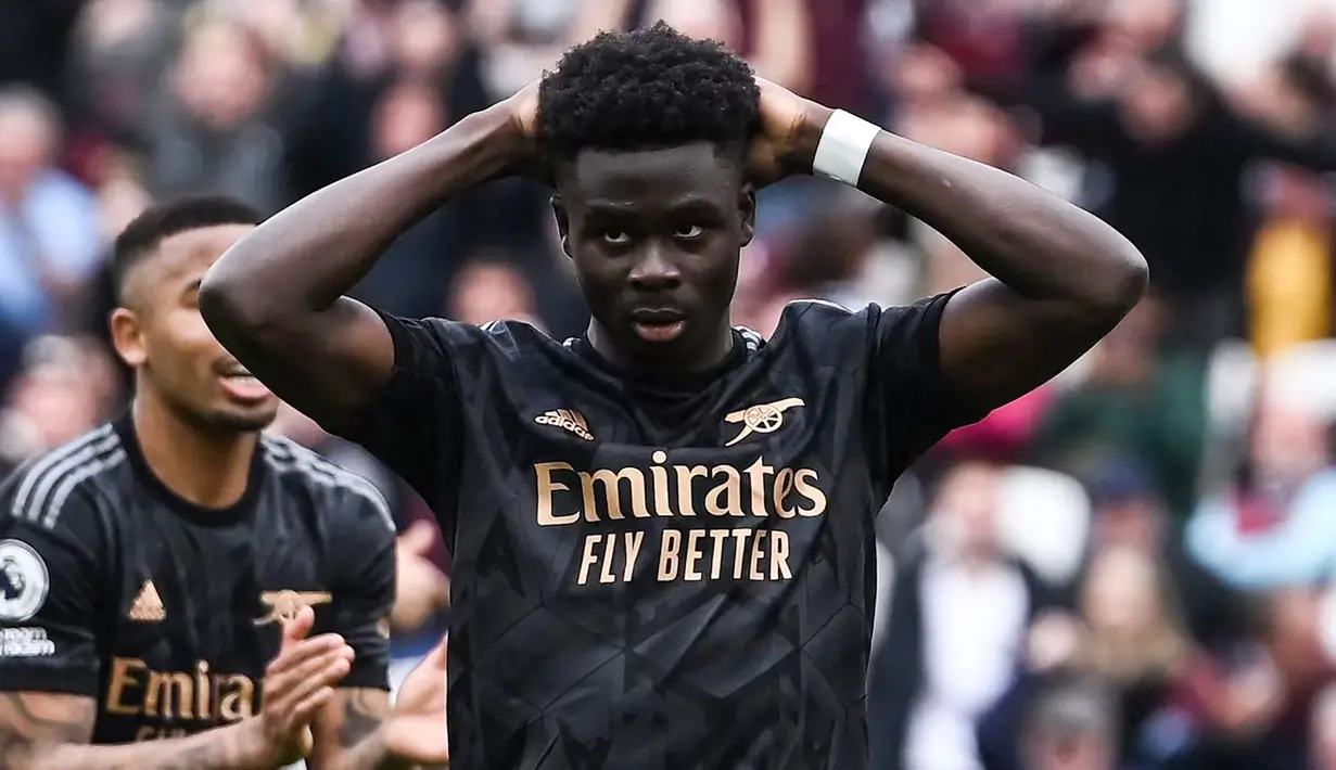 Reaksi kecewa pemain Arsenal, Bukayo Saka setelah gagal mencetak gol melalui tendangan penalti ke gawang West Ham pada laga lanjutan Liga Inggris 2022/2023 di London Stadium, London, 16 April  2023. Nasib The Gunners lagi-lagi seperti saat melawan Liverpool. Sempat unggul 2-0 melalui Gabriel Jesus dan Martin Odegaard. The Gunners sempat memiliki peluang untuk memperbesar kedudukan saat skor 2-1 melalui tendangan penalti Bukayo Saka. Bukannya mencetak gol, skuad asuhan Mikel Arteta tersebut malah membuang peluang dan tiga menit kemudian kebobolan melalui Jarrod Bowen. Laga pun kembali berakhir dengan skor 2-2. (AFP/Ben Stansall)